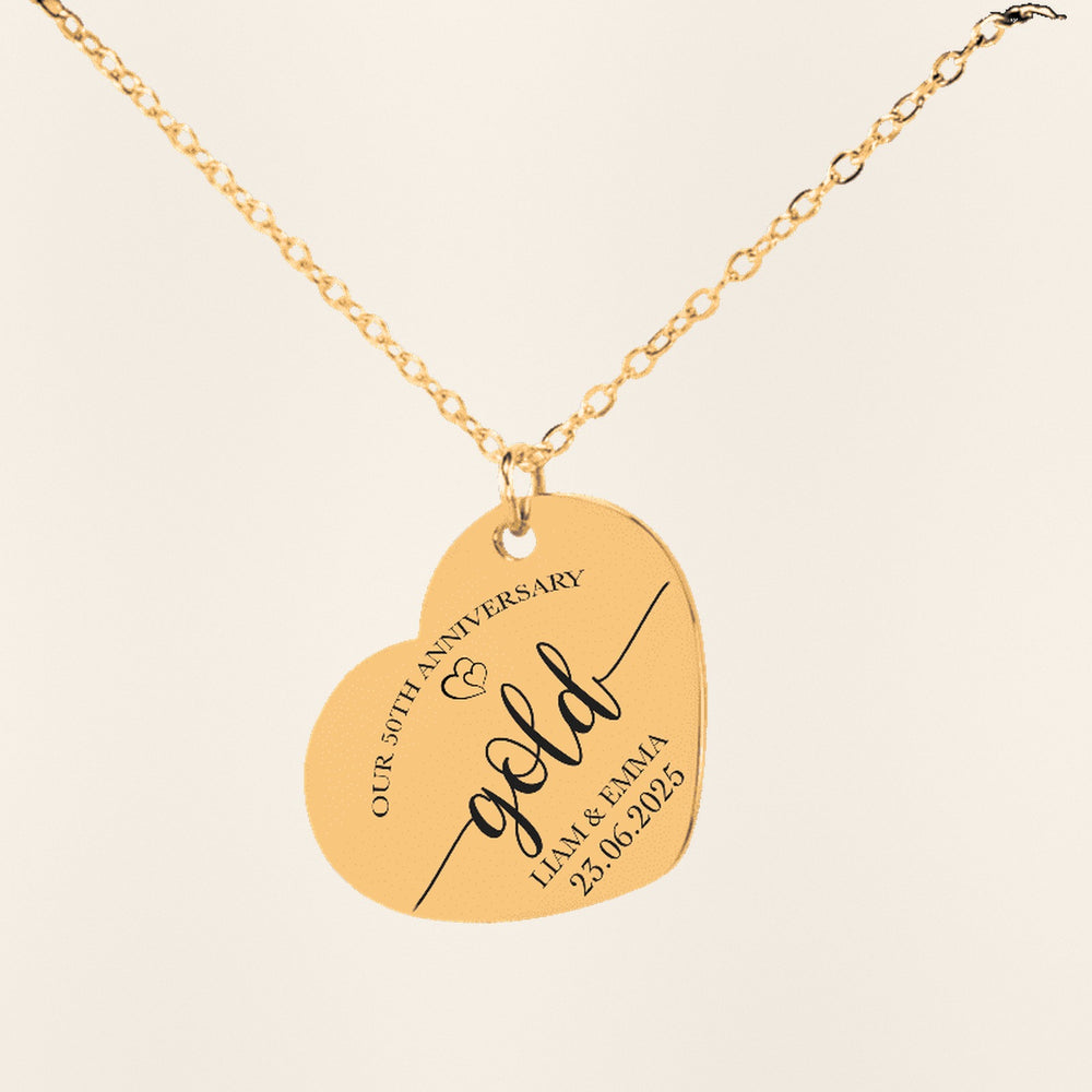 Collier Coeur Anniversaire de Mariage 50 ans en finition dorée, exemple de gravure sur fond ivoire texturé.