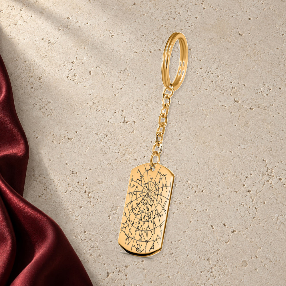 Porte-clés Carte des Étoiles Personnalisé (Plaque) en finition dorée sur pierre claire, avec étoffe rouge sanguine ; exemple de personnalisation.