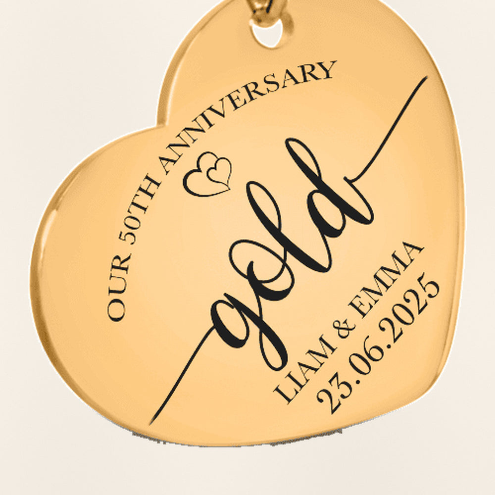 Porte-clés Coeur Anniversaire de Mariage 50 ans (noces d'or) : gros plan du motif gravé, exemple de personnalisation en finition dorée.