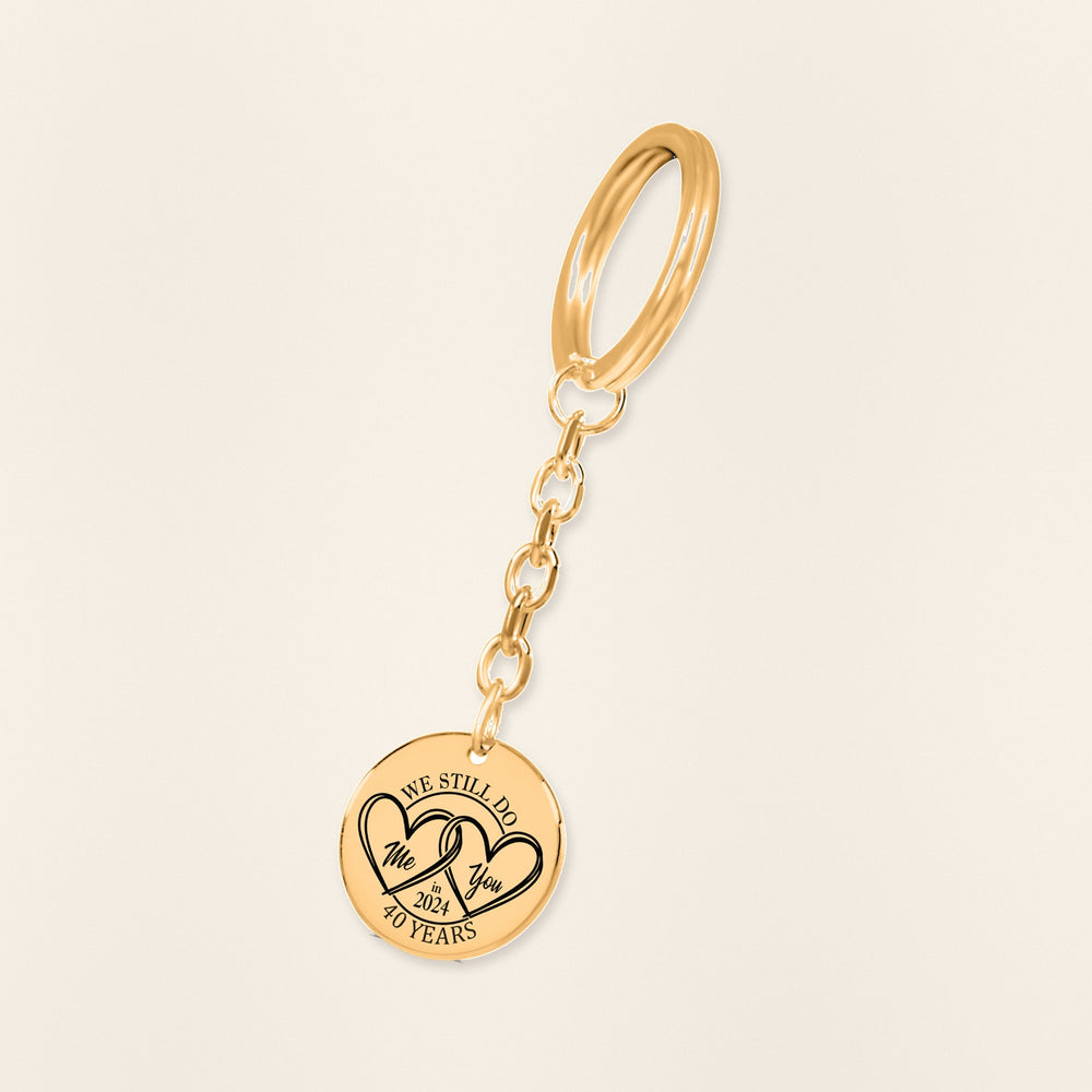 Porte-clés Médaille Anniversaire de Mariage 40 ans (noces d'émeraude) en finition dorée, exemple de gravure sur fond ivoire texturé.