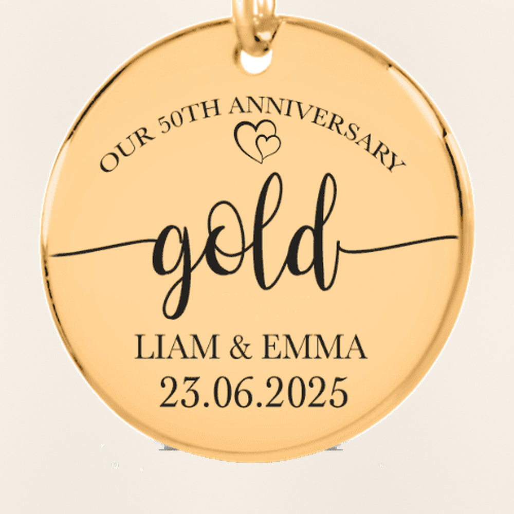 Porte-clés Médaille Anniversaire de Mariage 50 ans : gros plan du motif gravé, exemple de personnalisation en finition dorée.