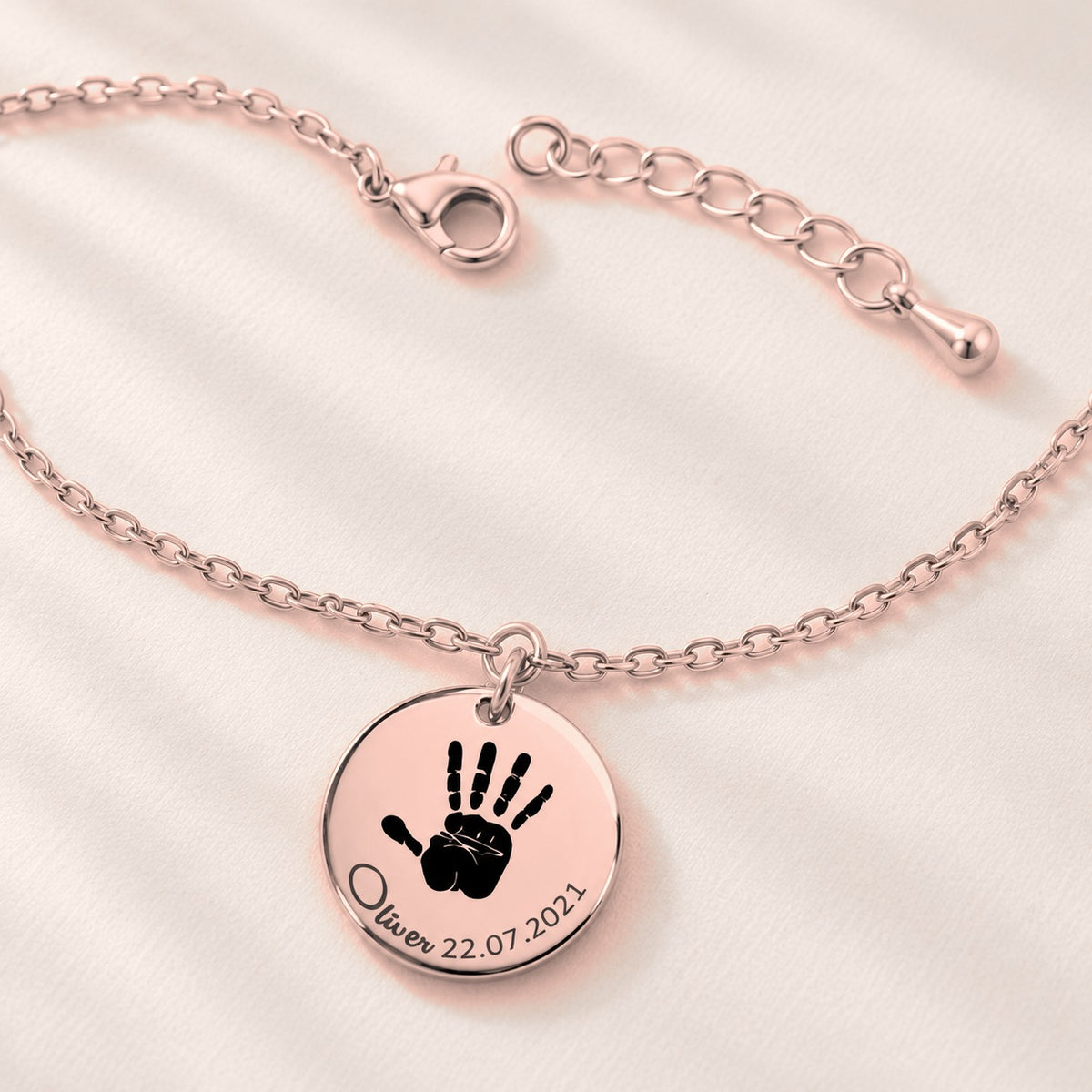 Bracelet Empreinte de Main Réelle Gravée, finition or rose, avec détail du bracelet et de ses attaches.