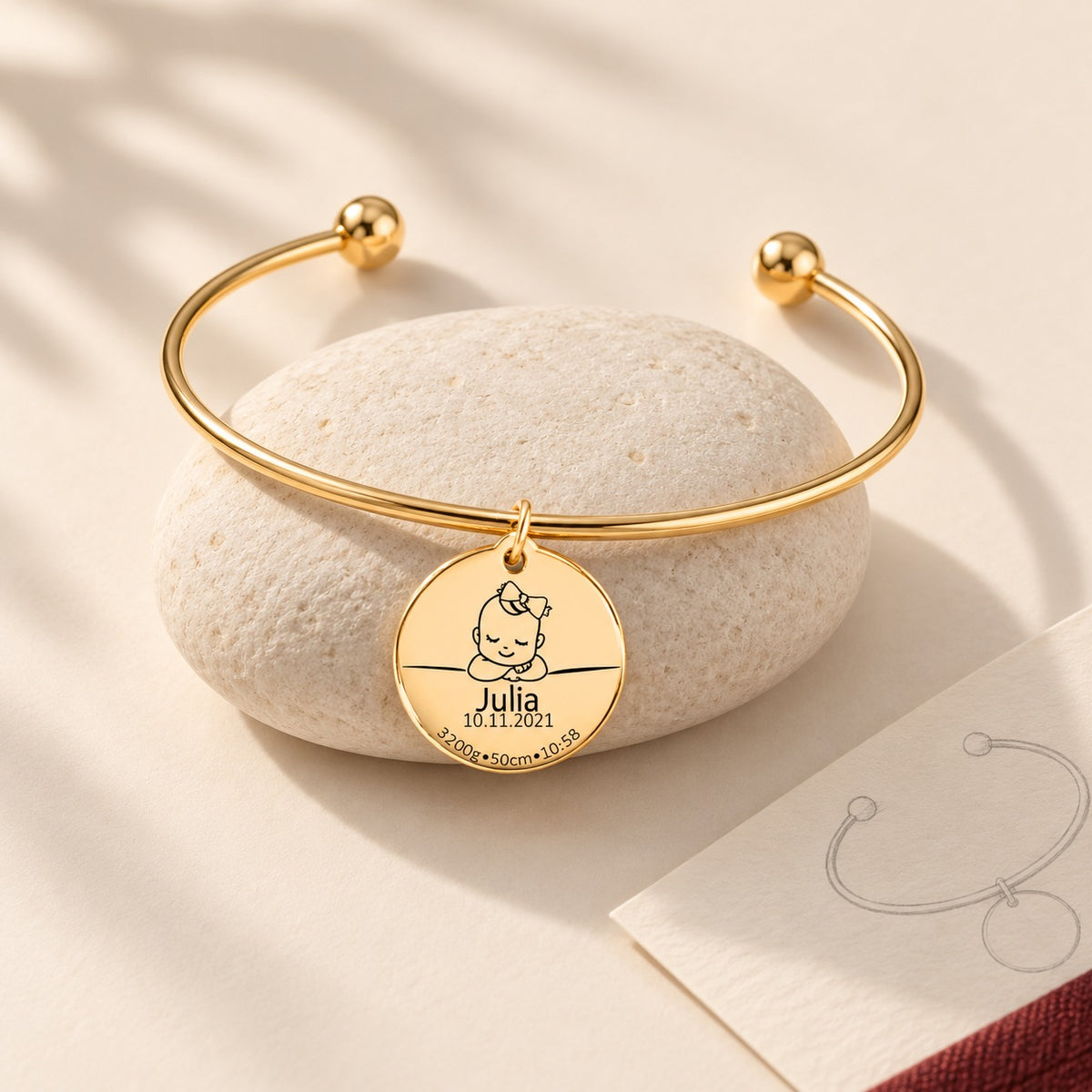 Armreif Personalisierte Geburtsdetails, finition dorée, sur une pierre claire.
