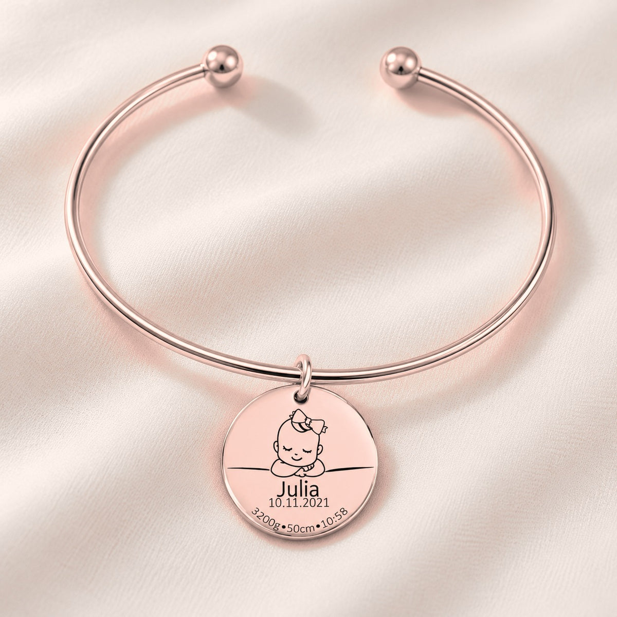 Bracelet jonc Détails de Naissance Personnalisés, finition or rose, avec détail du bracelet et de ses attaches.