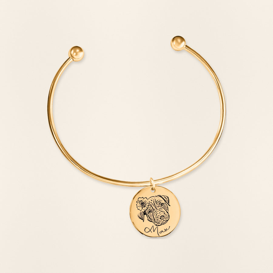Bracelet jonc Portrait d'Animal Personnalisé en finition dorée, exemple de gravure sur fond ivoire texturé.