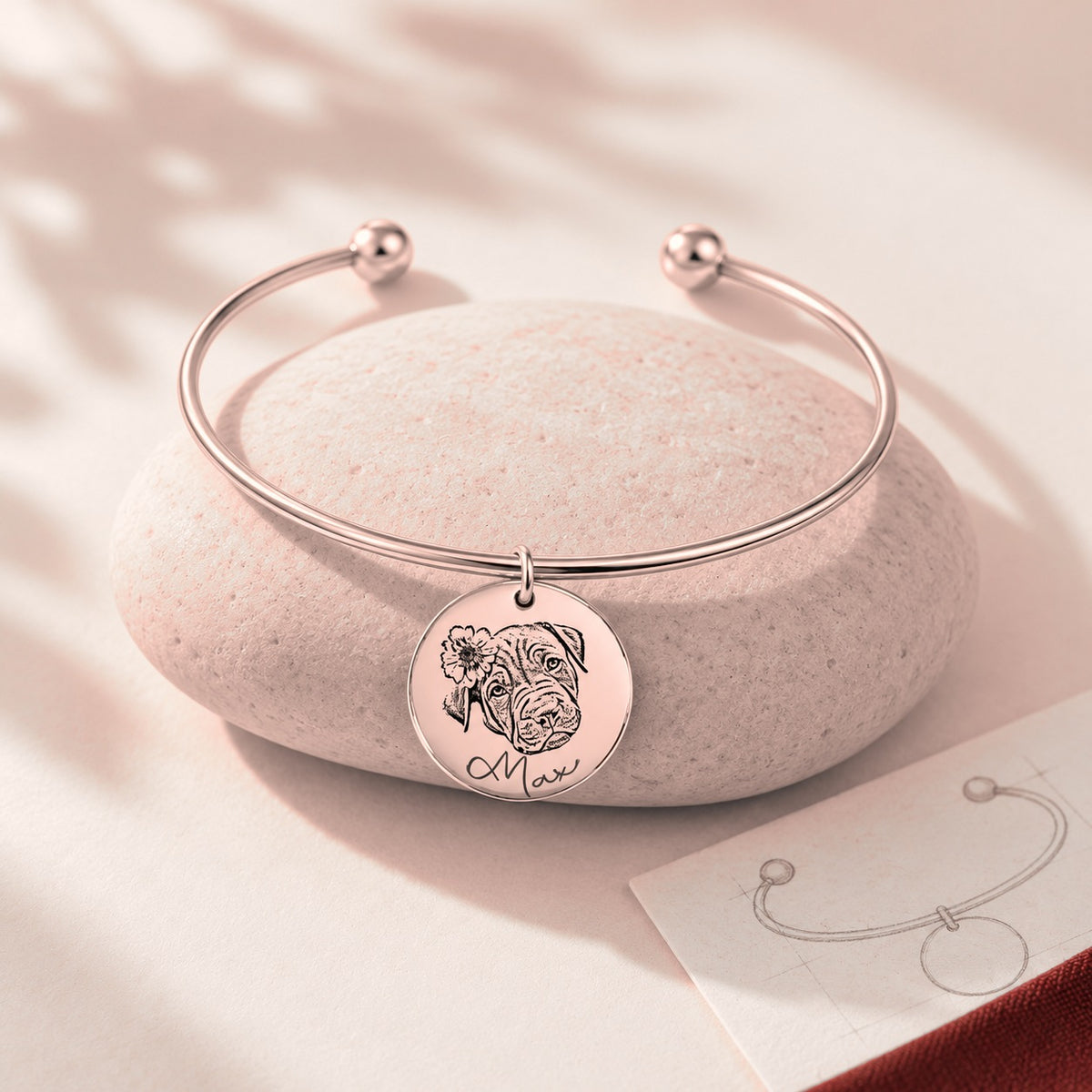Bracelet jonc Portrait d'Animal Personnalisé, finition or rose, sur une pierre claire.