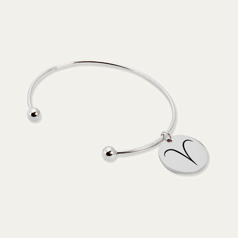 Bracelet jonc en finition argentée, médaille gravée du signe Bélier, sur fond ivoire.