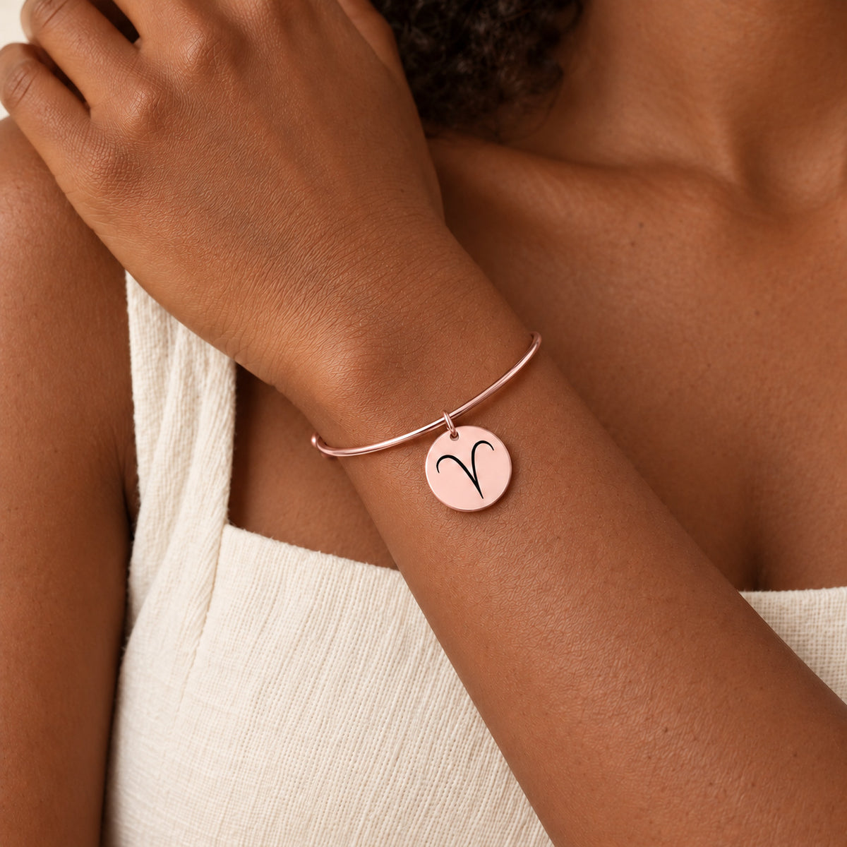 Bracelet Jonc Zodiaque, finition or rose, porté au poignet.