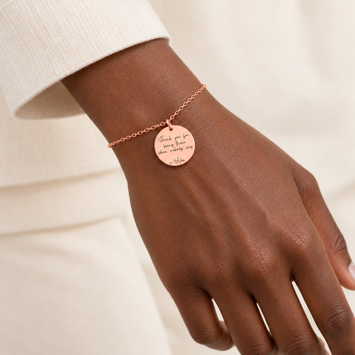 Bracelet Message Personnalisé, finition or rose, porté au poignet.