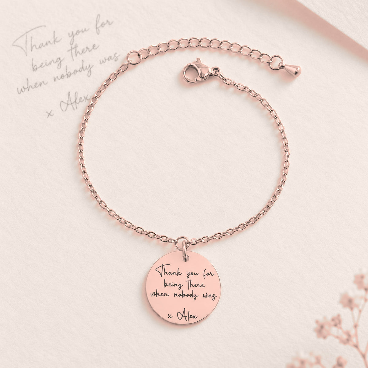 Bracelet Message Personnalisé, finition or rose, près d’un croquis au crayon.