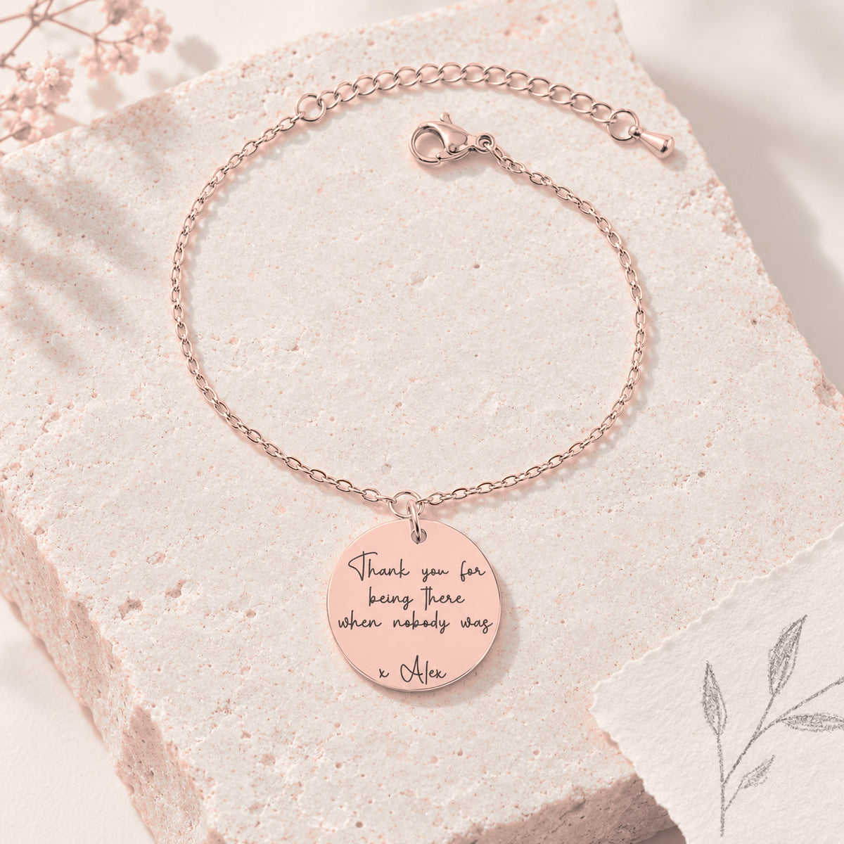 Bracelet Message Personnalisé, finition or rose, sur une pierre claire.