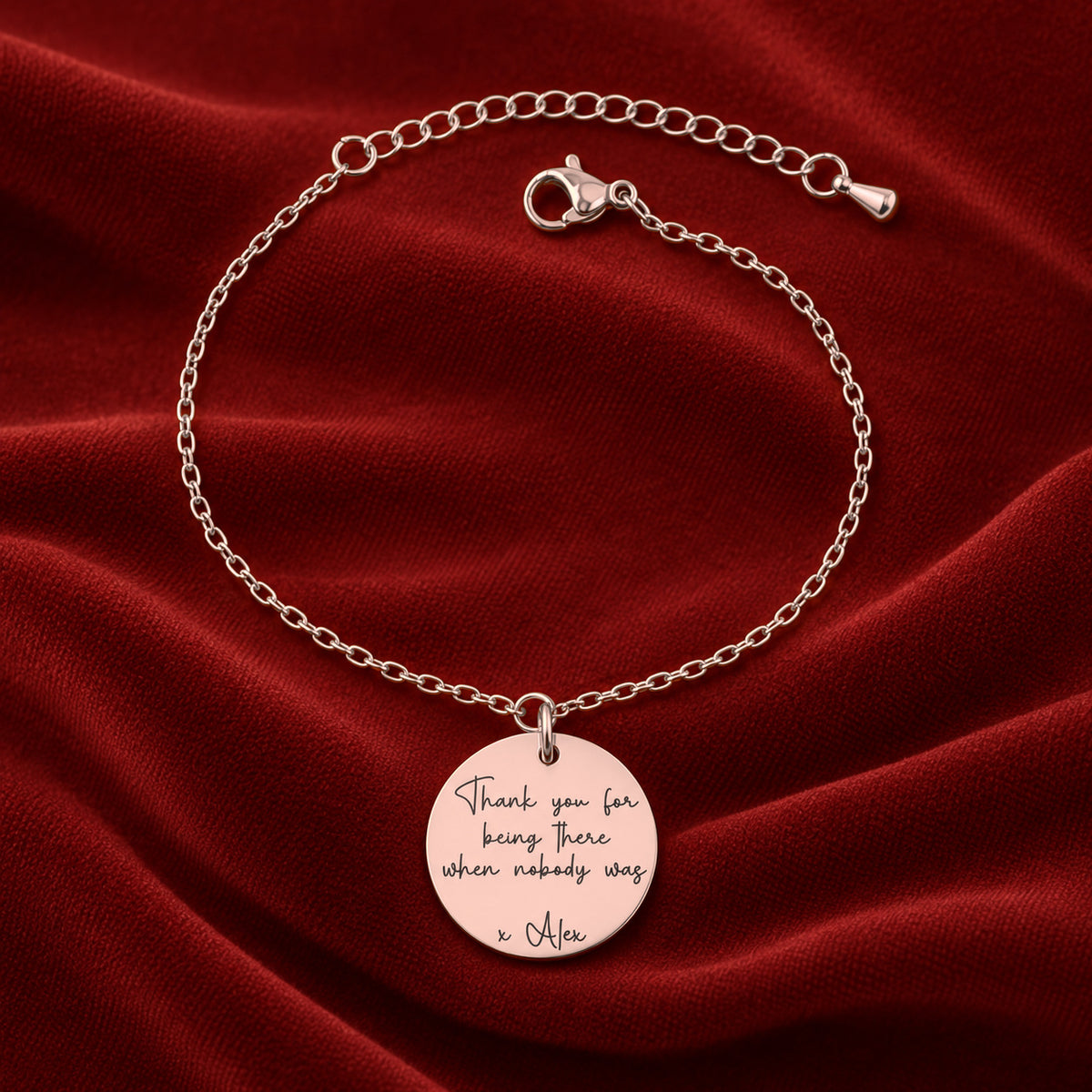 Bracelet Message Personnalisé, finition or rose, sur fond rouge sanguine.