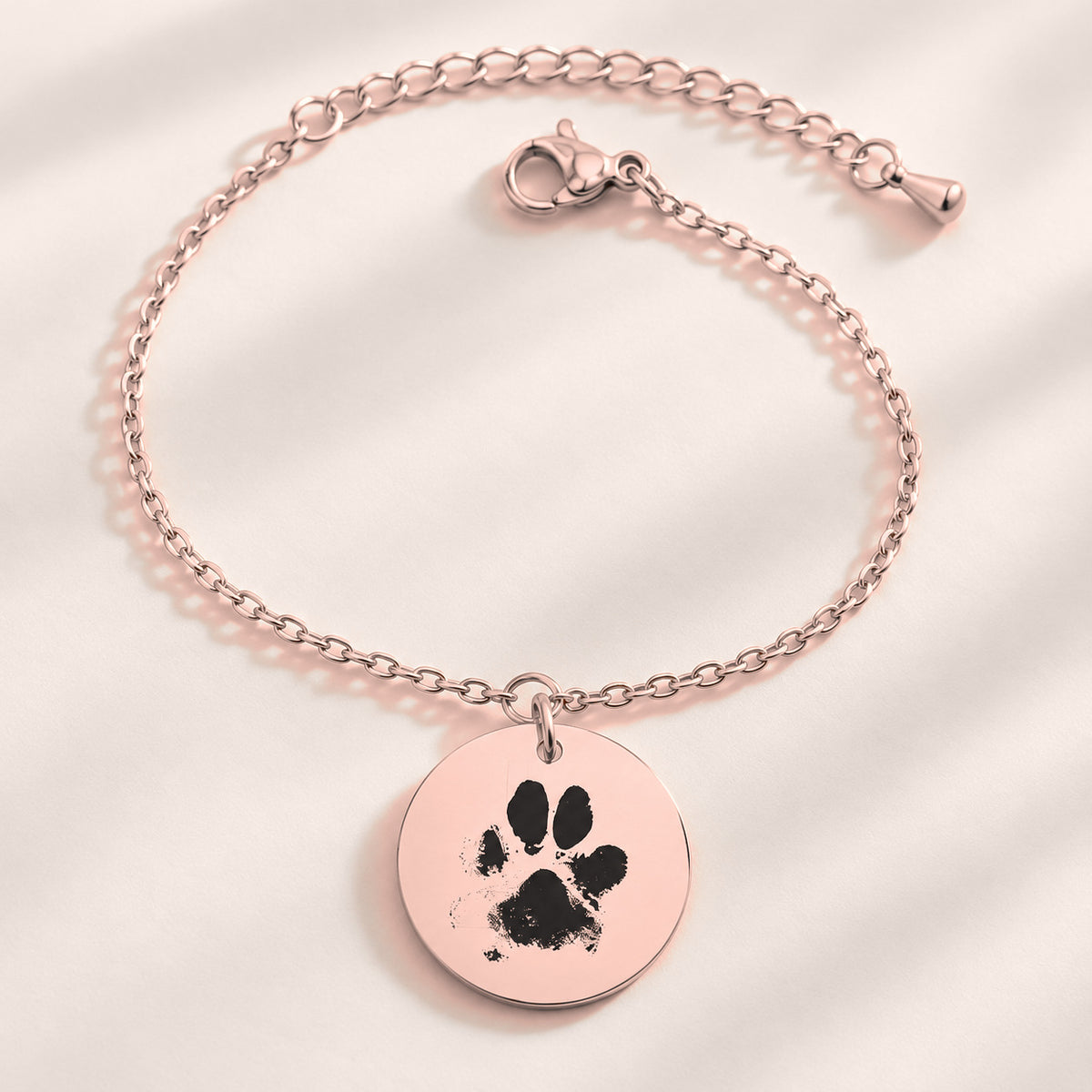 Bracelet personnalisé avec empreinte de patte, finition or rose, avec détail du bracelet et de ses attaches.
