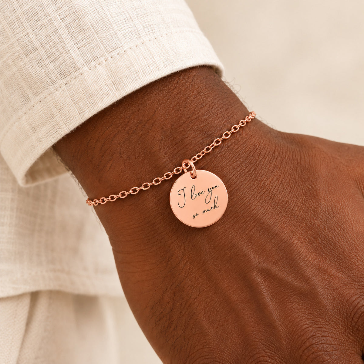 Bracelet Personnalisé avec message écrit, finition or rose, porté au poignet.