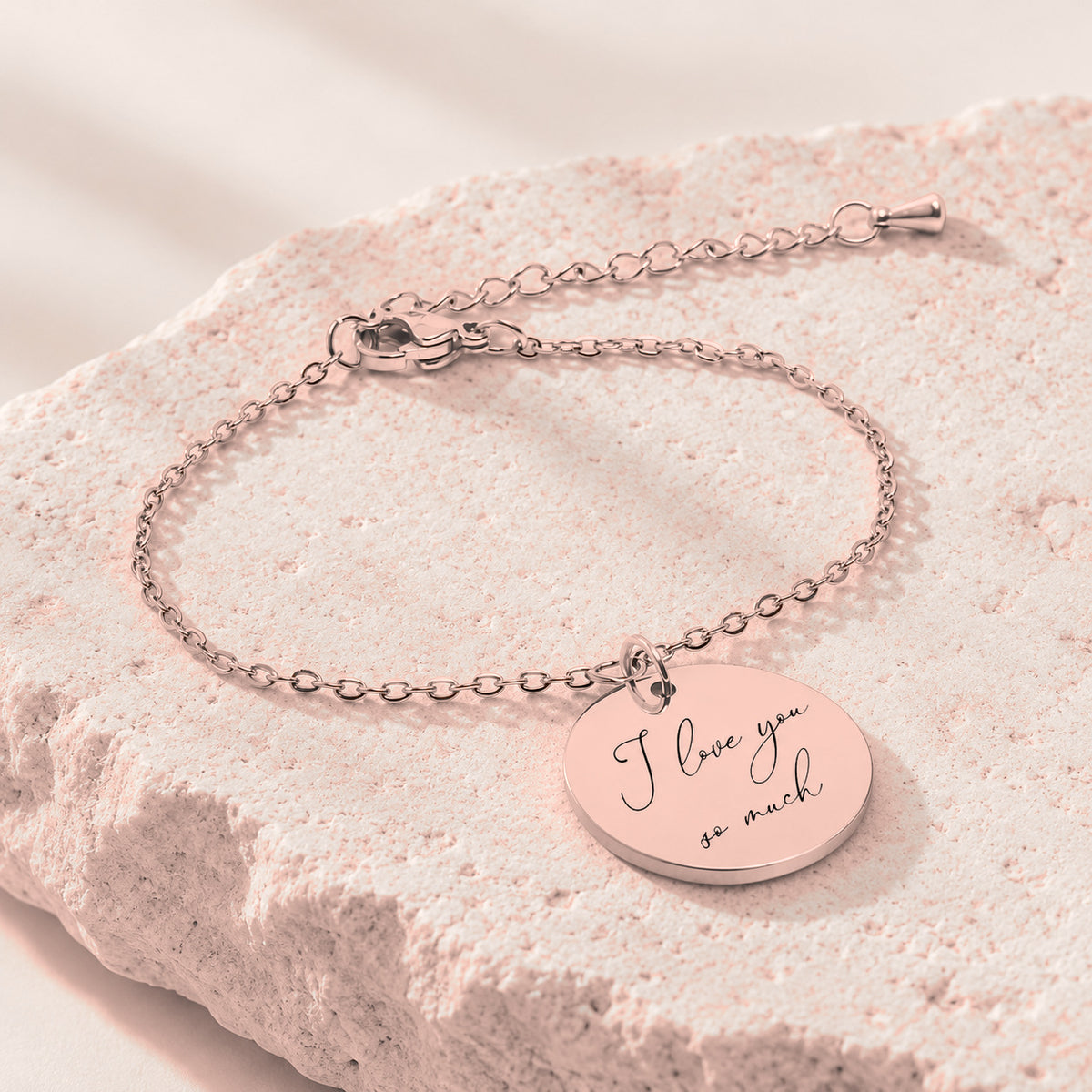 Bracelet Personnalisé avec message écrit, finition or rose, sur une pierre claire.