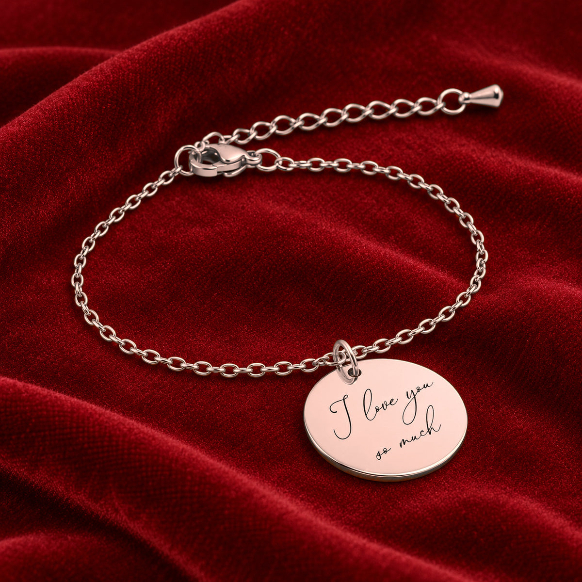 Bracelet Personnalisé avec message écrit, finition or rose, sur fond rouge sanguine.