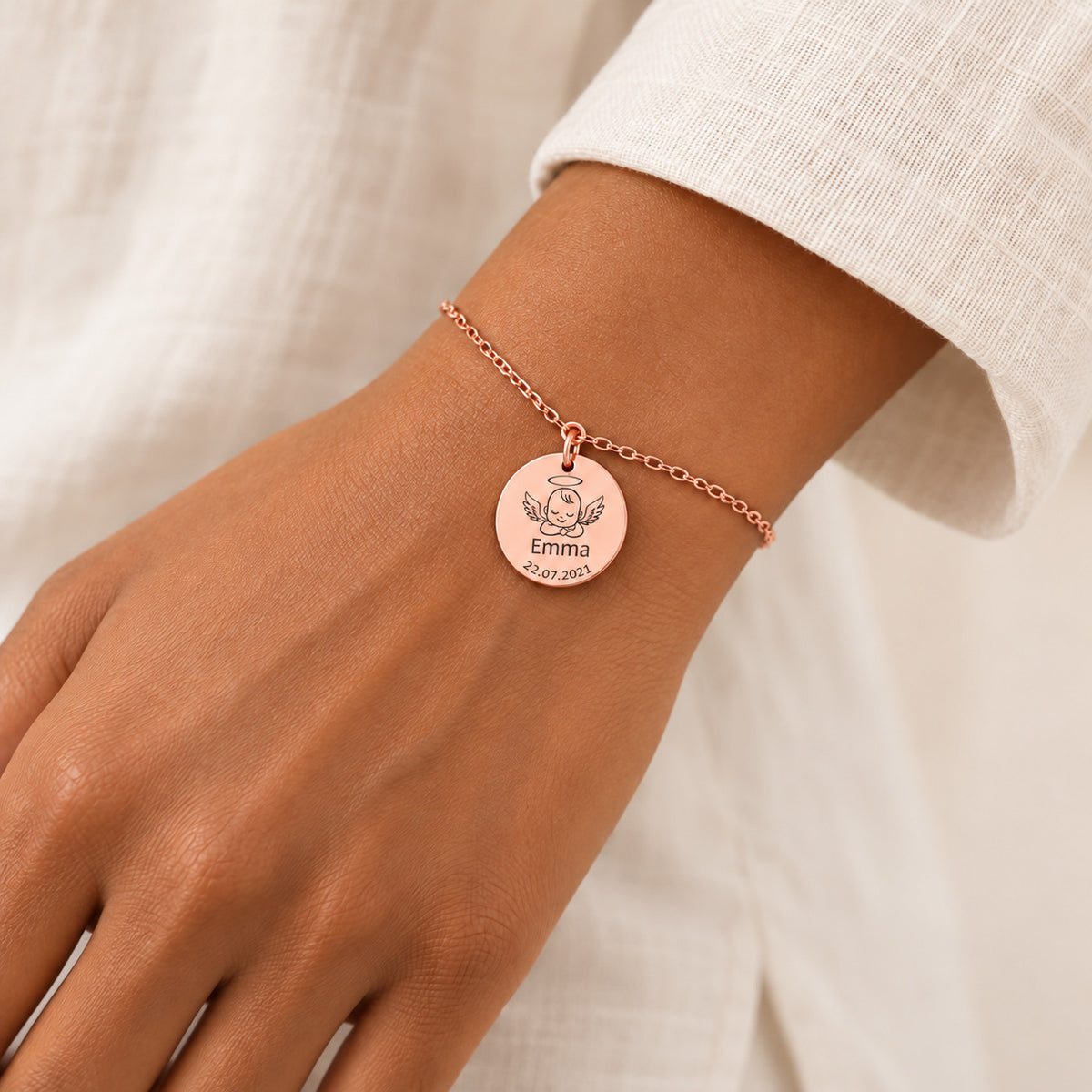 Bracelet Personnalisé Bébé Ange, finition or rose, porté au poignet.