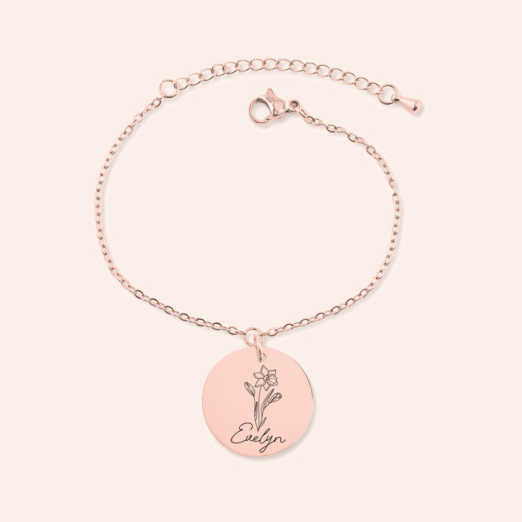 Bracelet Personnalisé de Naissance avec Fleur & Prénom, finition or rose, sur fond ivoire.