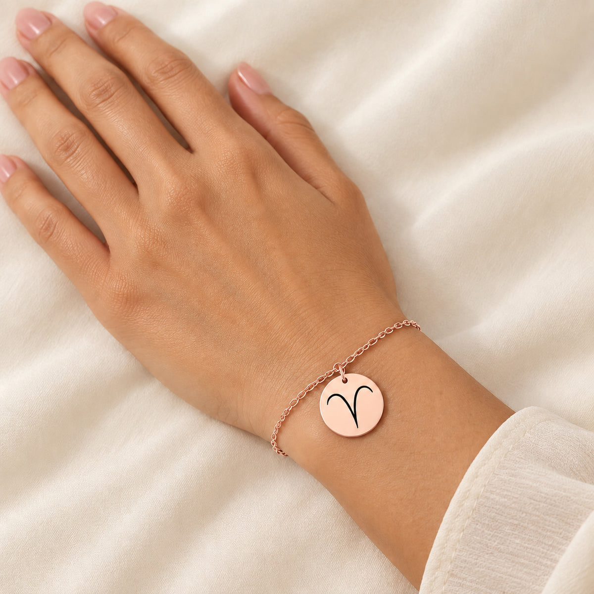 Bracelet Signe Astrologique, finition or rose, porté au poignet.