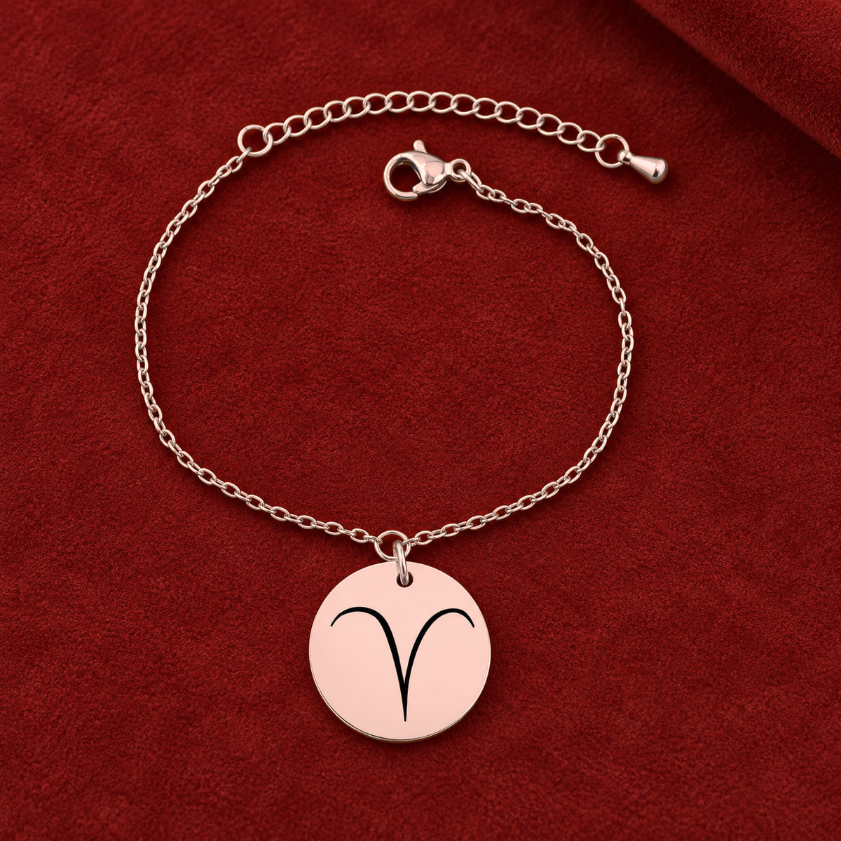 Bracelet Signe Astrologique, finition or rose, sur fond rouge sanguine.