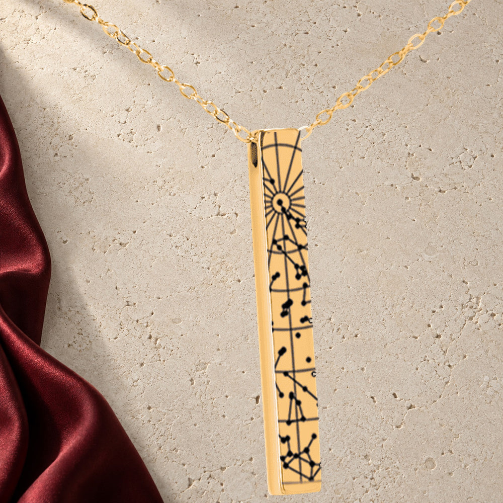 Collier Carte des Étoiles Personnalisé (Barre 3D) en finition dorée sur pierre claire, avec étoffe rouge sanguine ; exemple de personnalisation.