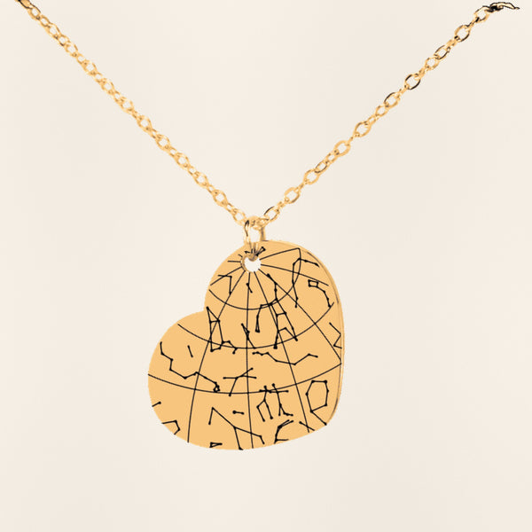 Collier Carte des Étoiles Personnalisé (Coeur) en finition dorée, exemple de gravure sur fond ivoire texturé.