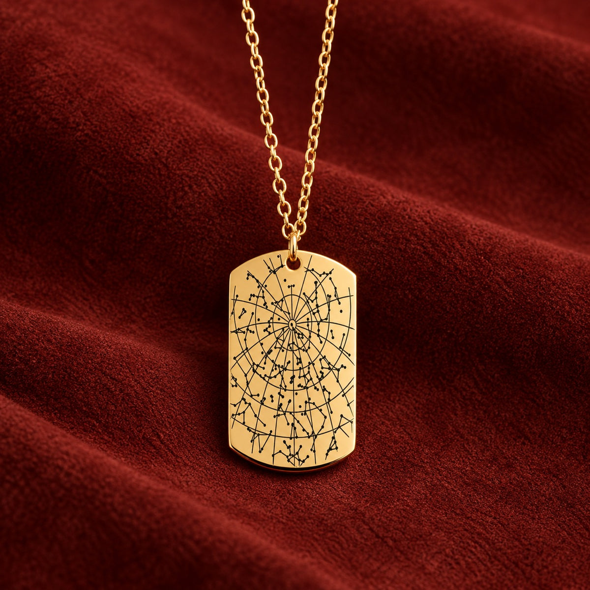 Pendentif doré en forme de plaque, gravé avec carte des étoiles sur suédine rouge sanguine.