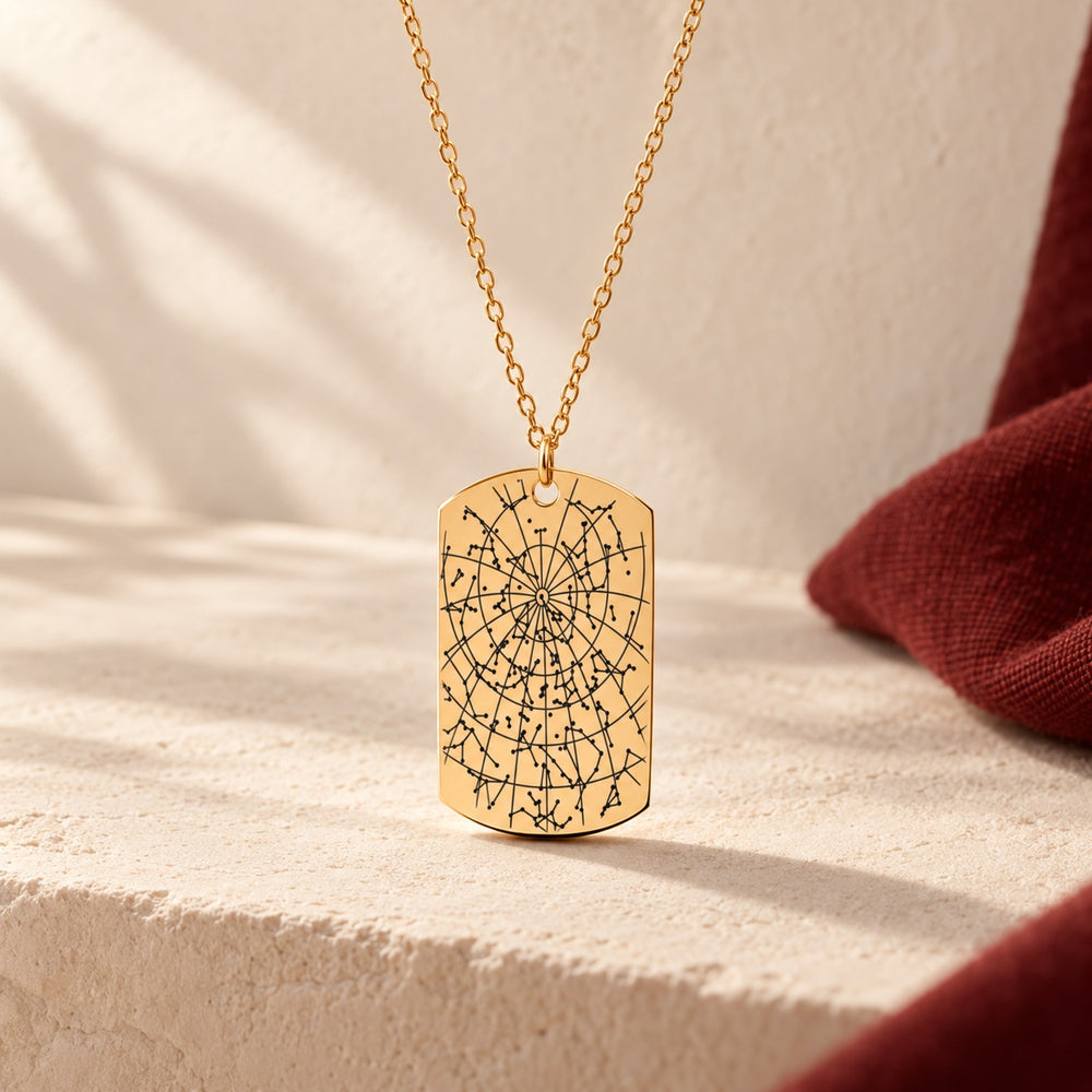 Collier Carte des Étoiles doré, pendentif en forme de plaque avec carte des étoiles sur fond ivoire.