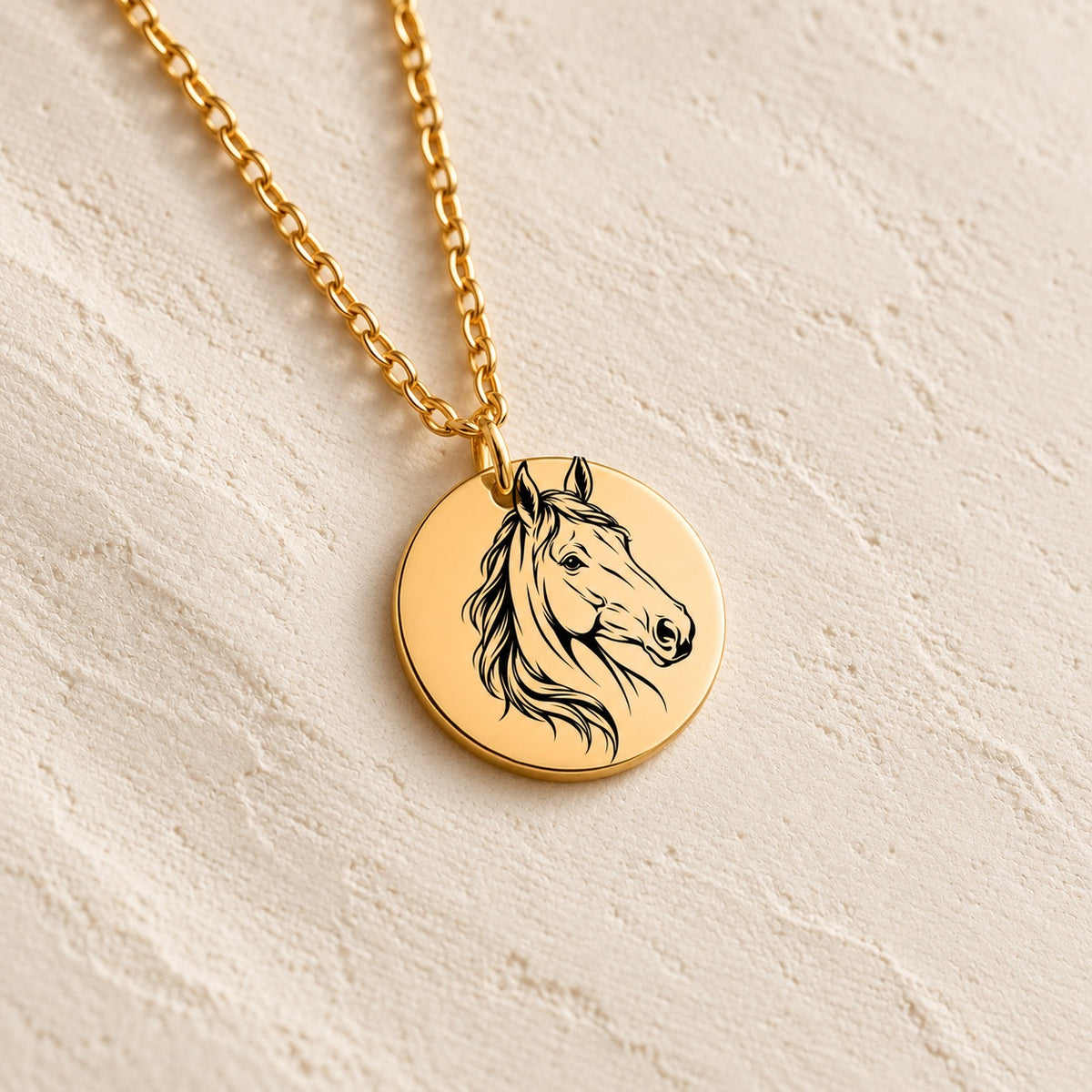 Détail du portrait de cheval gravé sur la médaille ronde dorée, sur fond ivoire.
