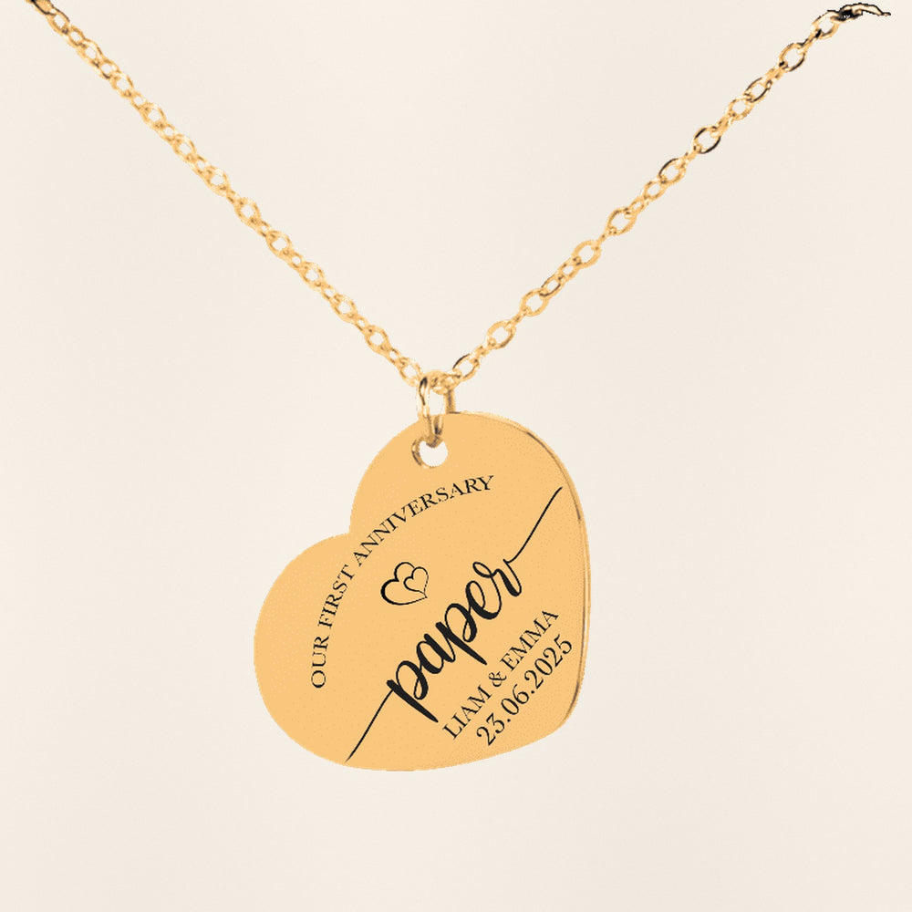 Collier Coeur Anniversaire de Mariage 1 an (noces de coton) en finition dorée, exemple de gravure sur fond ivoire texturé.