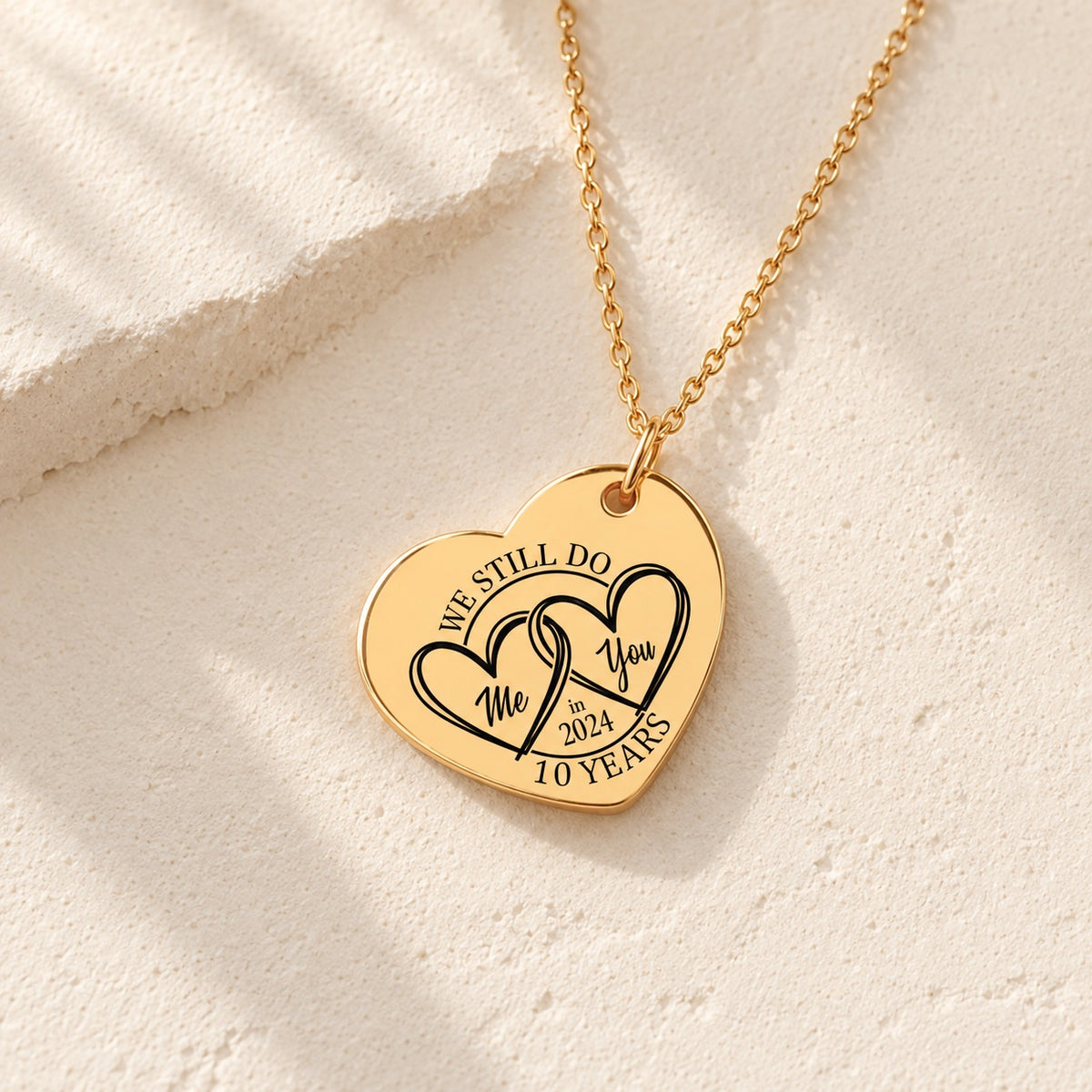 Détail de la médaille en cœur dorée gravée avec deux cœurs et inscription « 10 YEARS ».