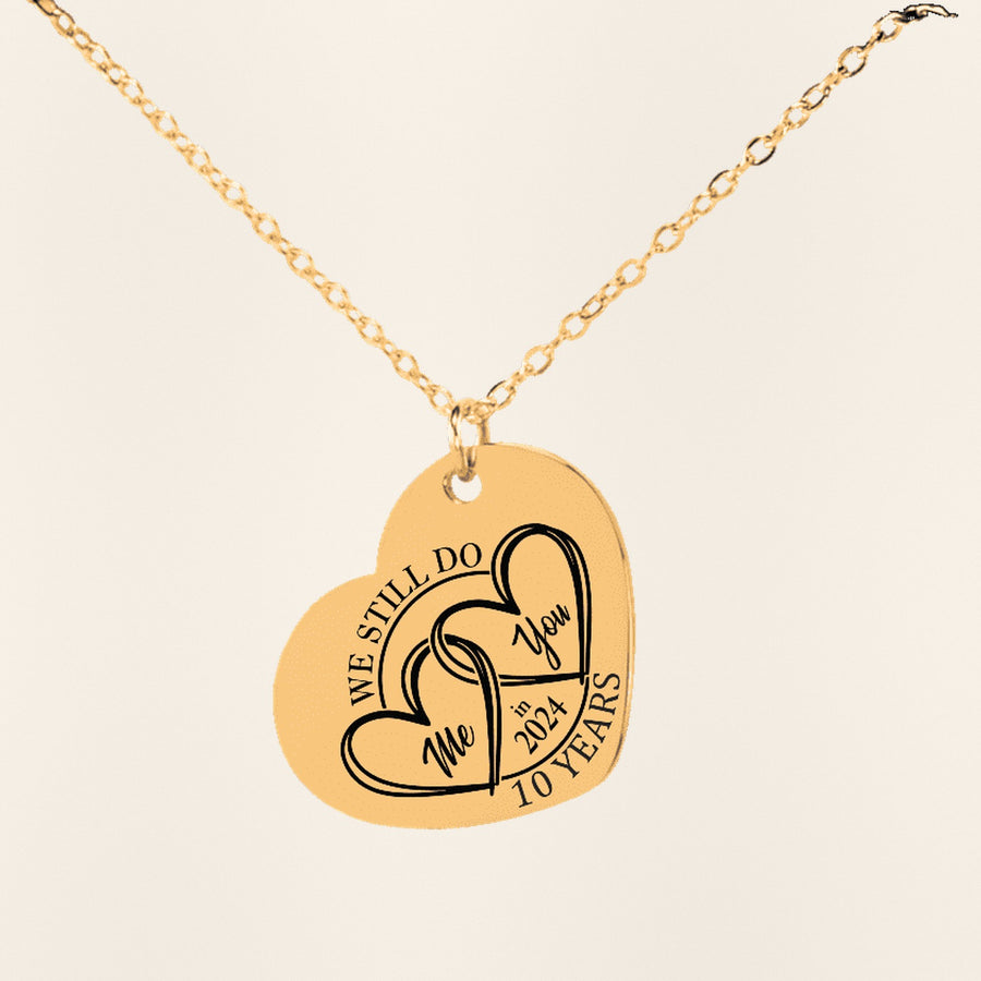Collier Coeur Anniversaire de Mariage 10 ans (noces d'étain) en finition dorée, exemple de gravure sur fond ivoire texturé.