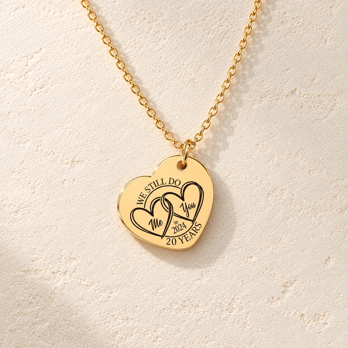 Détail de la médaille en cœur dorée avec deux cœurs et inscription « 20 YEARS ».