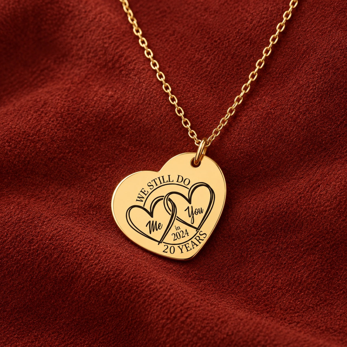 Médaille en cœur dorée avec deux cœurs et inscription « 20 YEARS », sur suédine rouge sanguine.