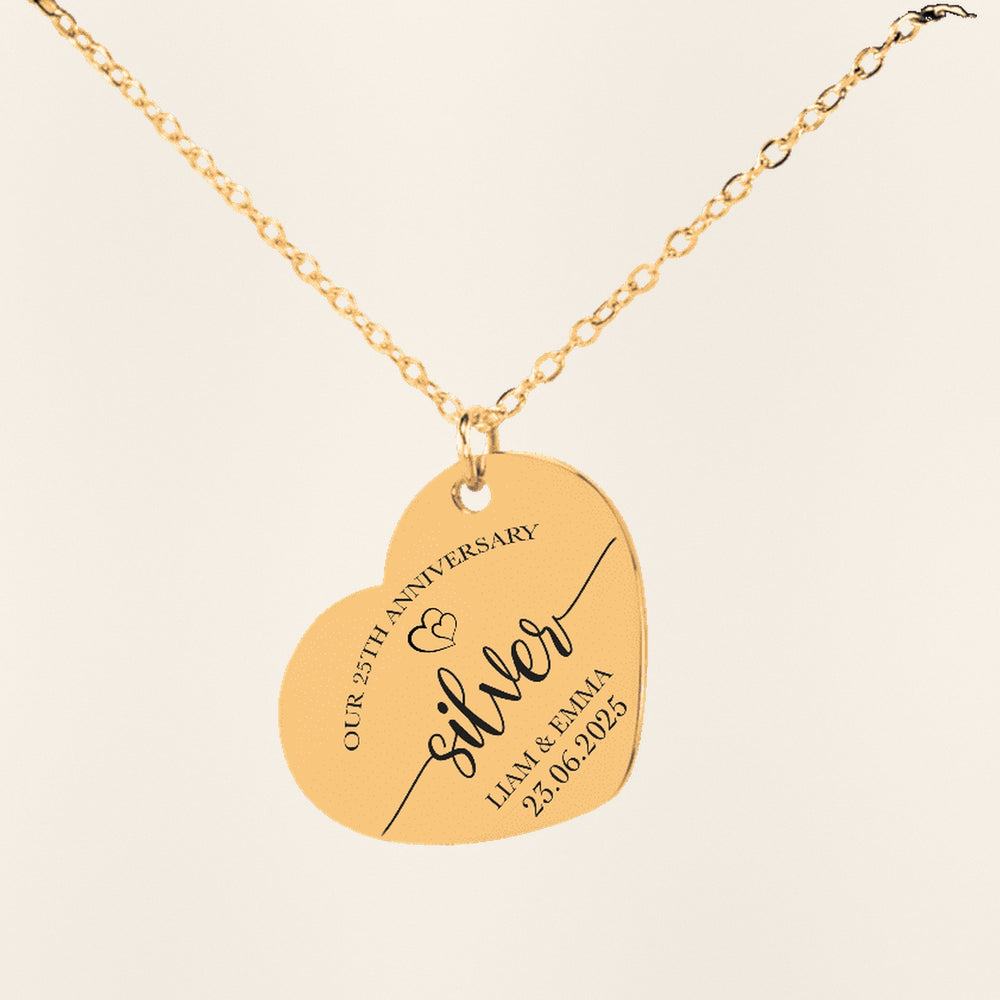 Collier Coeur Anniversaire de Mariage 25 ans en finition dorée, exemple de gravure sur fond ivoire texturé.