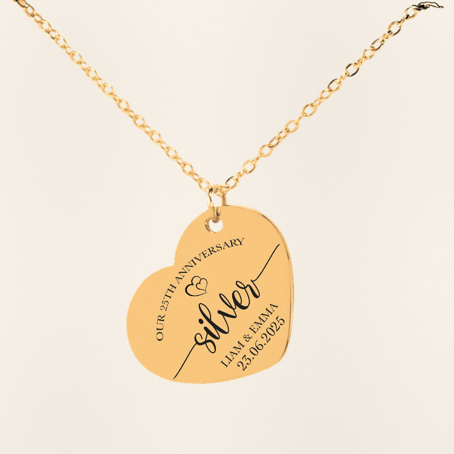 Collier Coeur Anniversaire de Mariage 25 ans en finition dorée, exemple de gravure sur fond ivoire texturé.