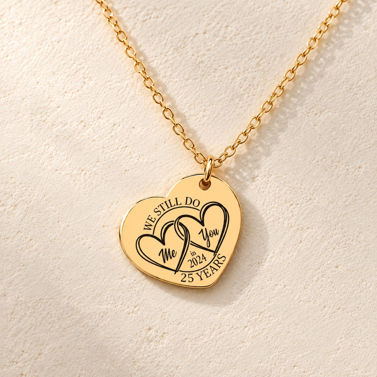 Détail de la médaille en cœur dorée avec deux cœurs et inscription « 25 YEARS ».
