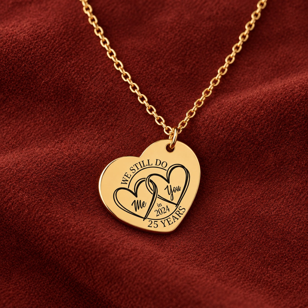 Médaille en cœur dorée avec deux cœurs et inscription « 25 YEARS », sur suédine rouge sanguine.