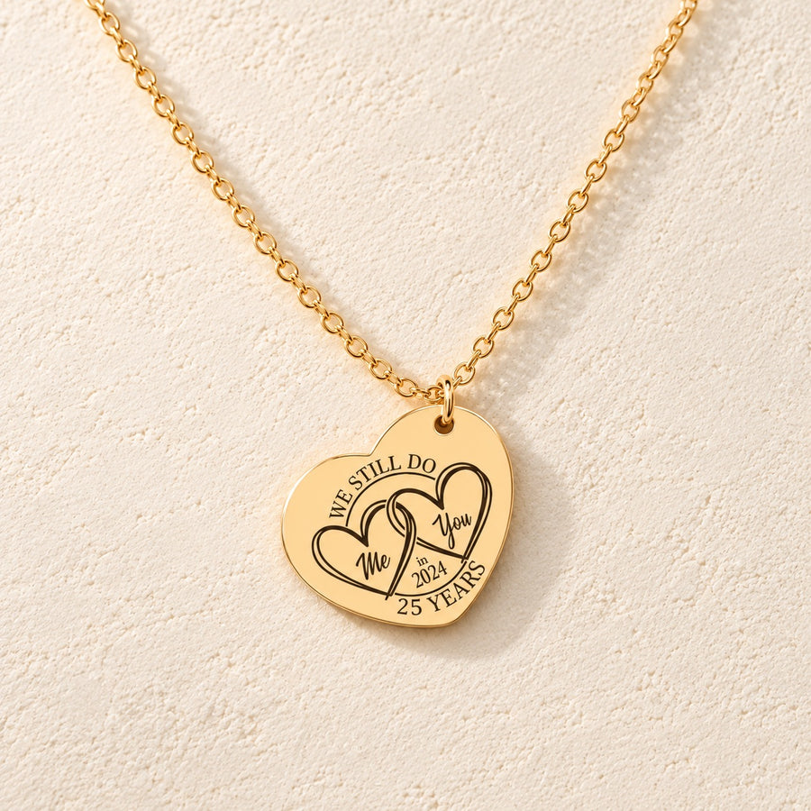 Collier cœur noces d’argent 25 ans doré, médaille en cœur gravée avec deux cœurs et inscription « 25 YEARS », sur fond ivoire.