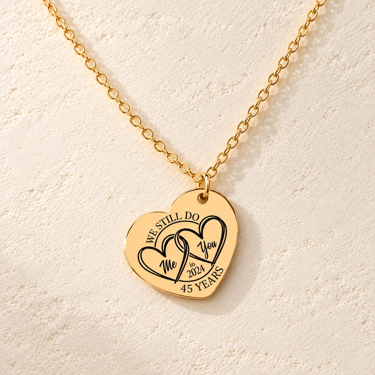 Détail de la médaille en cœur dorée avec deux cœurs et inscription « 45 YEARS ».