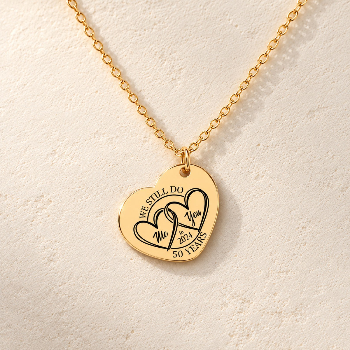 Détail de la médaille en cœur dorée avec deux cœurs et inscription « 50 YEARS ».