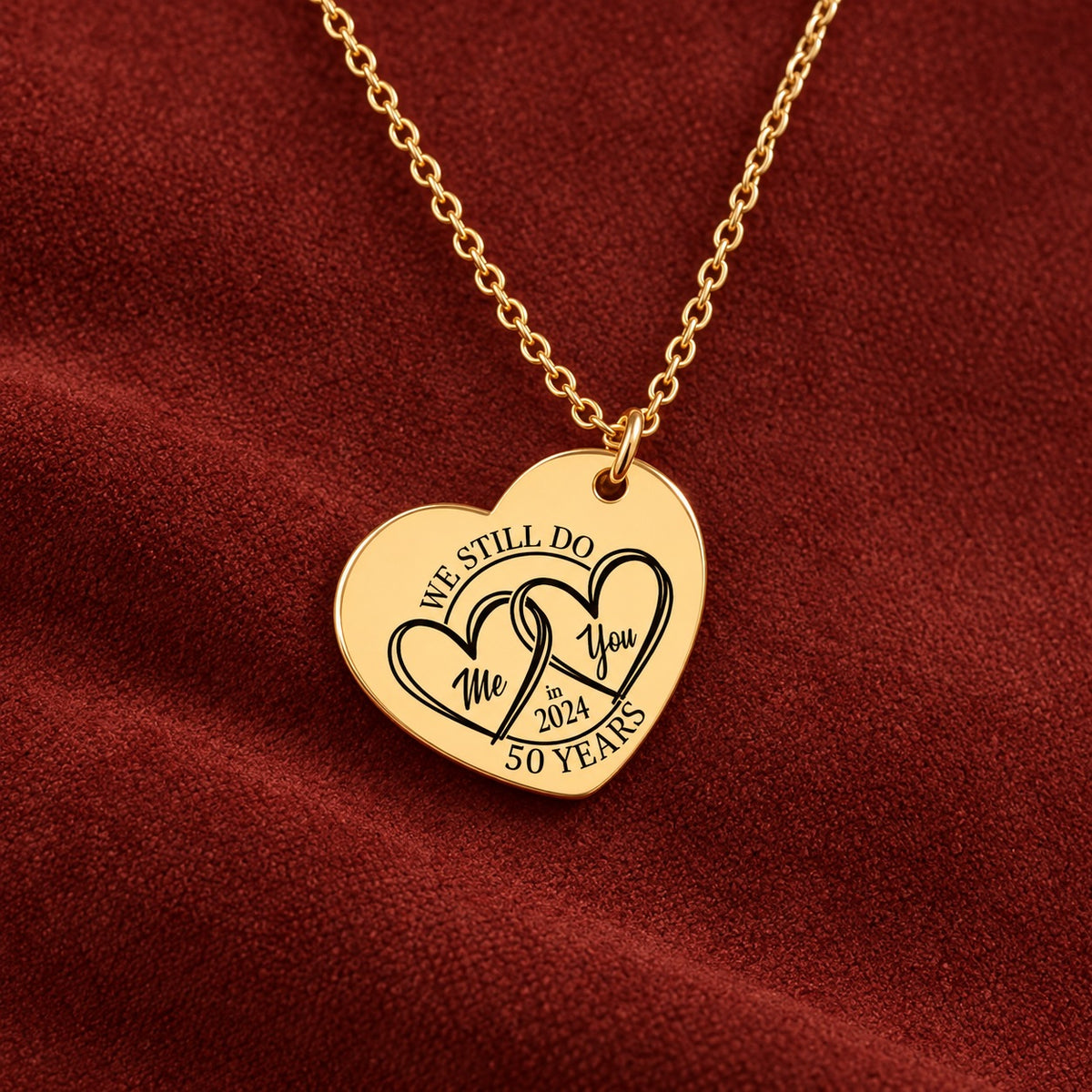 Médaille en cœur dorée avec deux cœurs et inscription « 50 YEARS », sur suédine rouge sanguine.