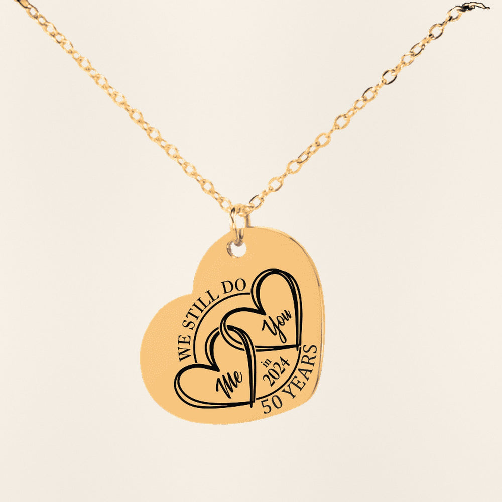 Collier Coeur Anniversaire de Mariage 50 ans (noces d'or) en finition dorée, exemple de gravure sur fond ivoire texturé.