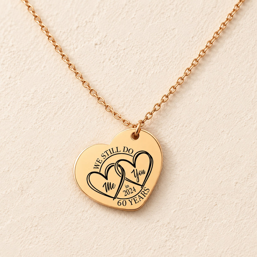 Collier cœur anniversaire de mariage 60 ans doré, médaille en cœur gravée avec deux cœurs et inscription « 60 YEARS », sur fond ivoire.