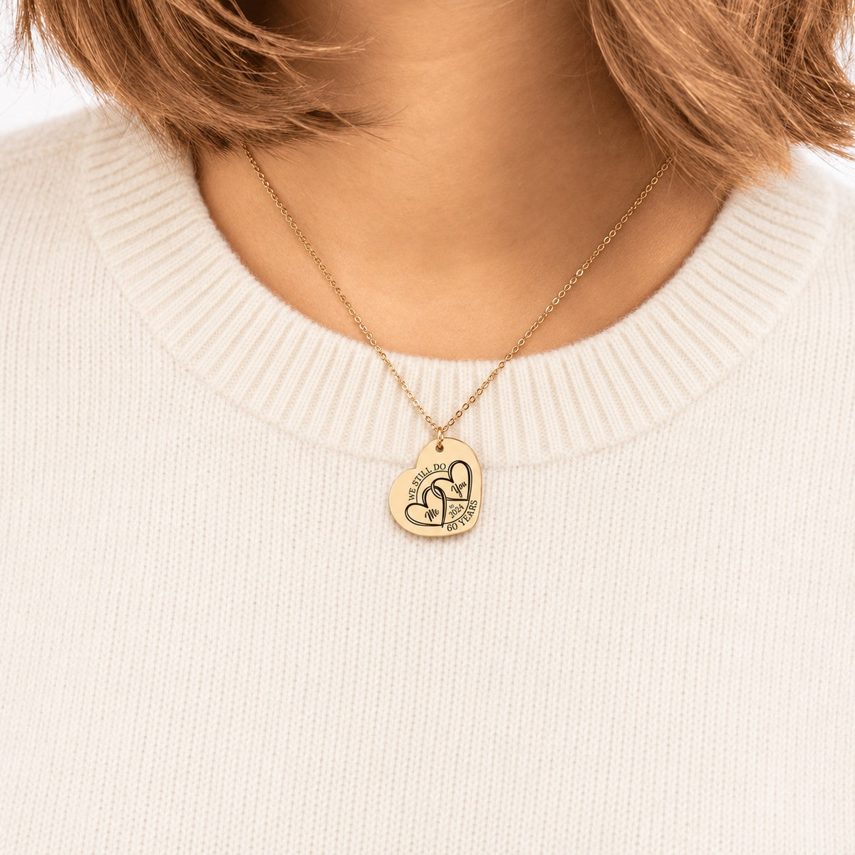 Collier cœur anniversaire de mariage 60 ans doré porté au cou, médaille en cœur personnalisée.