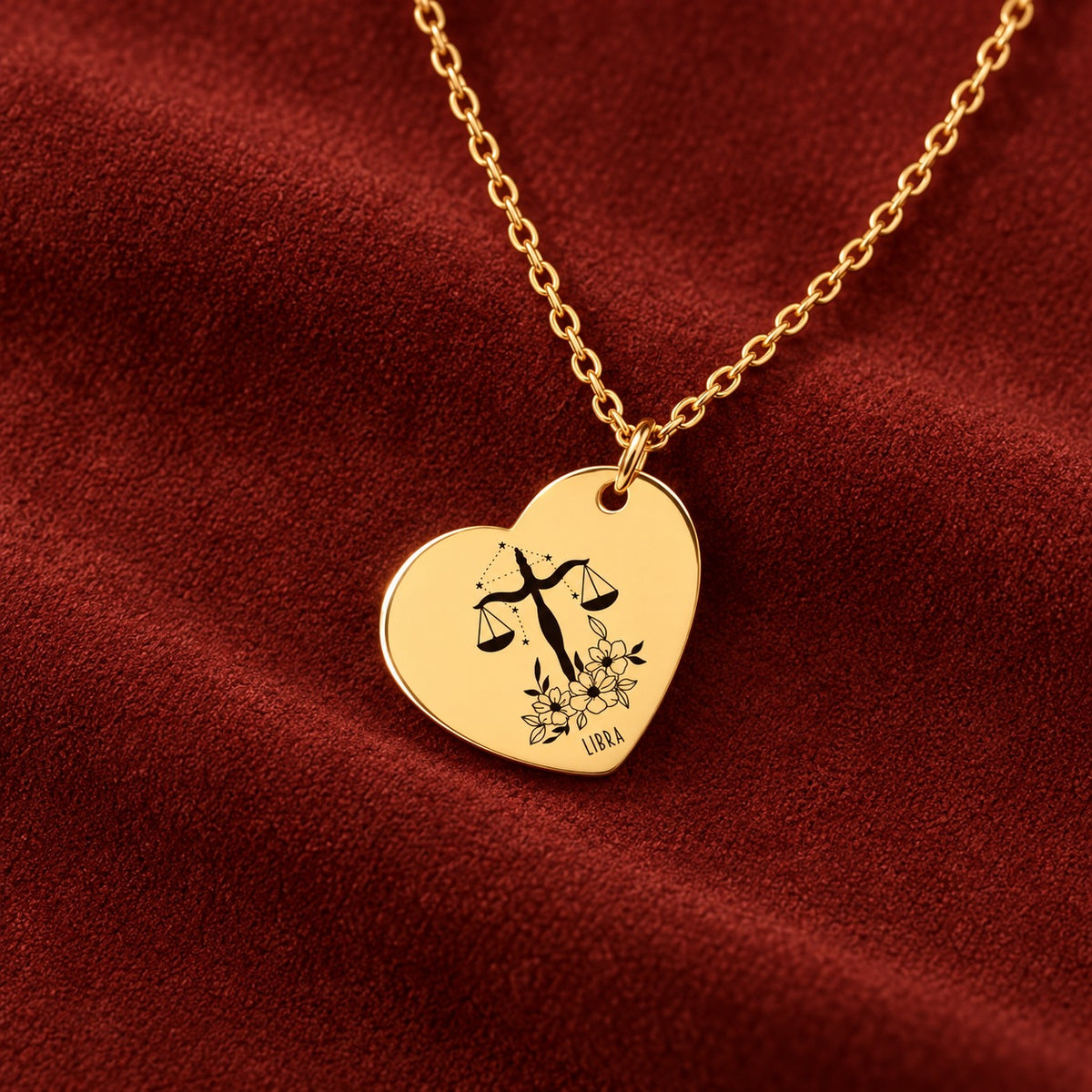 Médaille en cœur dorée avec motif du signe Balance et ornements, sur suédine rouge sanguine.
