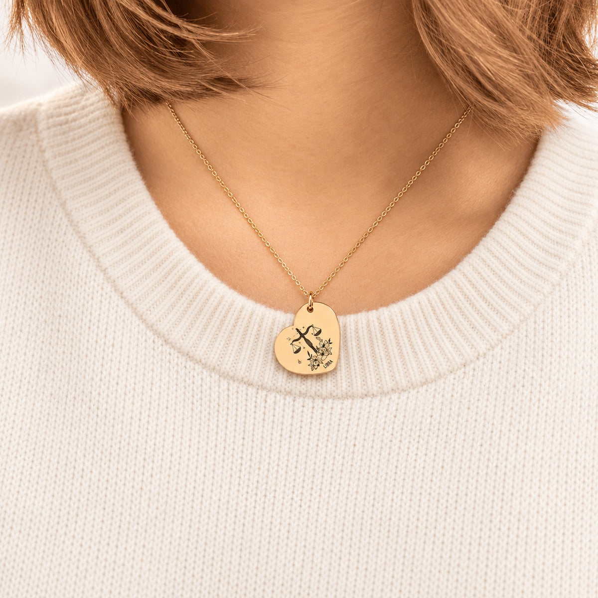 Collier cœur signe astrologique Balance doré porté au cou, médaille en cœur gravée.