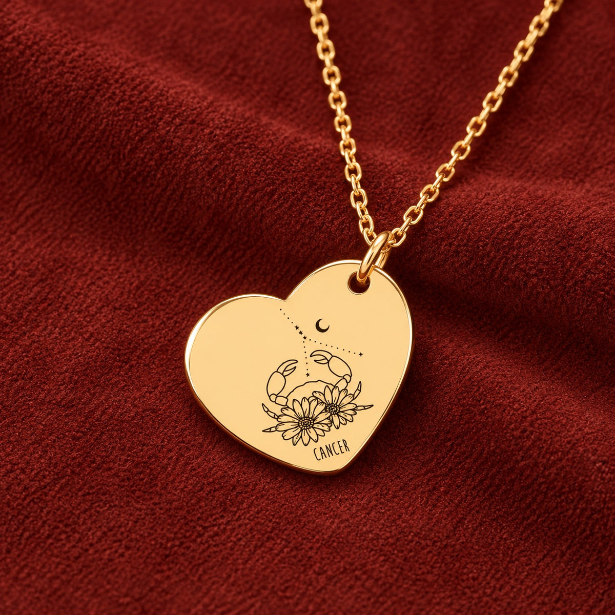 Médaille en cœur dorée avec motif du signe Cancer et ornements, sur suédine rouge sanguine.