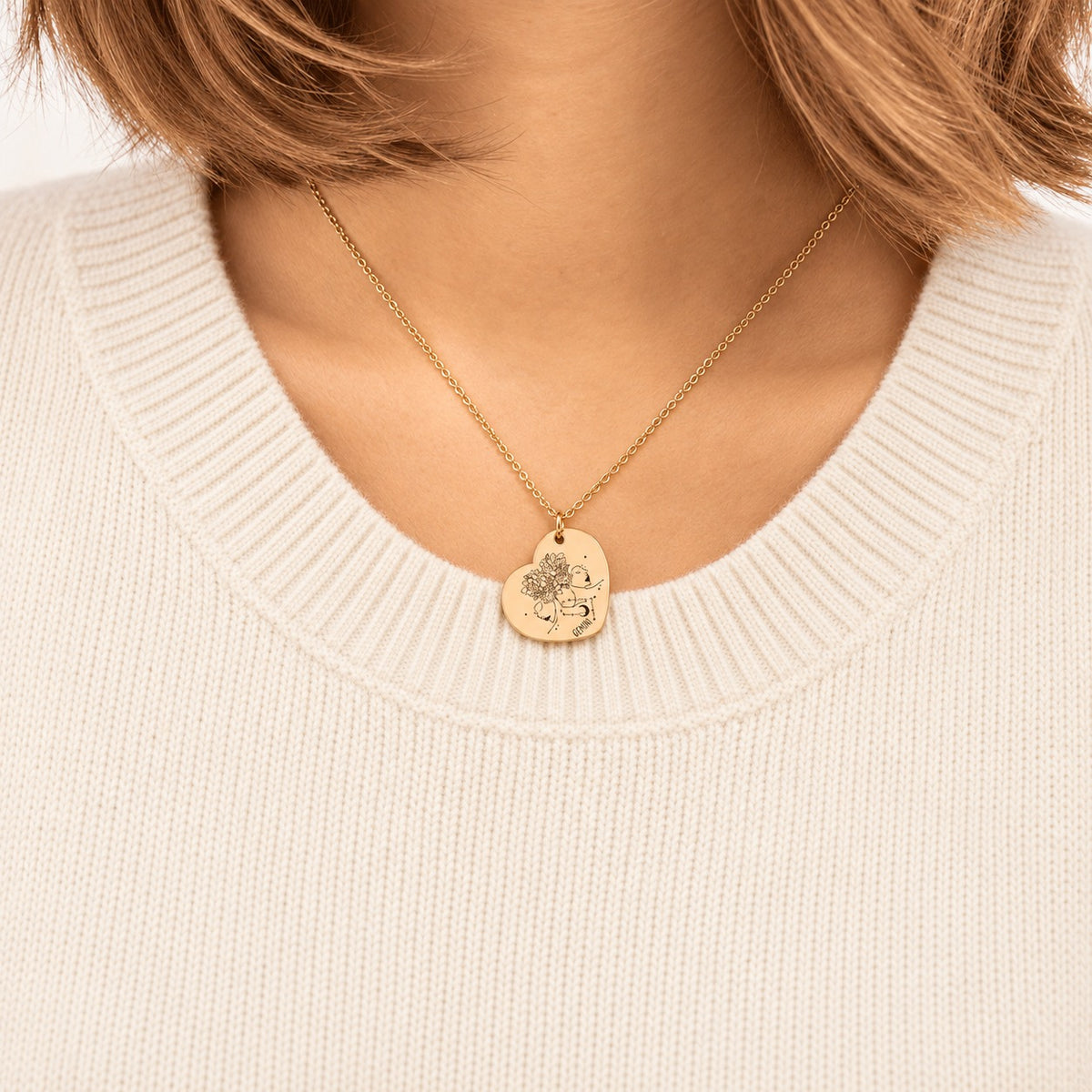 Collier cœur signe astrologique Gémeaux doré porté au cou, médaille en cœur gravée.