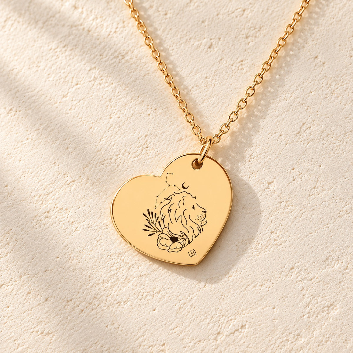 Détail de la médaille en cœur dorée avec motif du signe Lion et ornements.